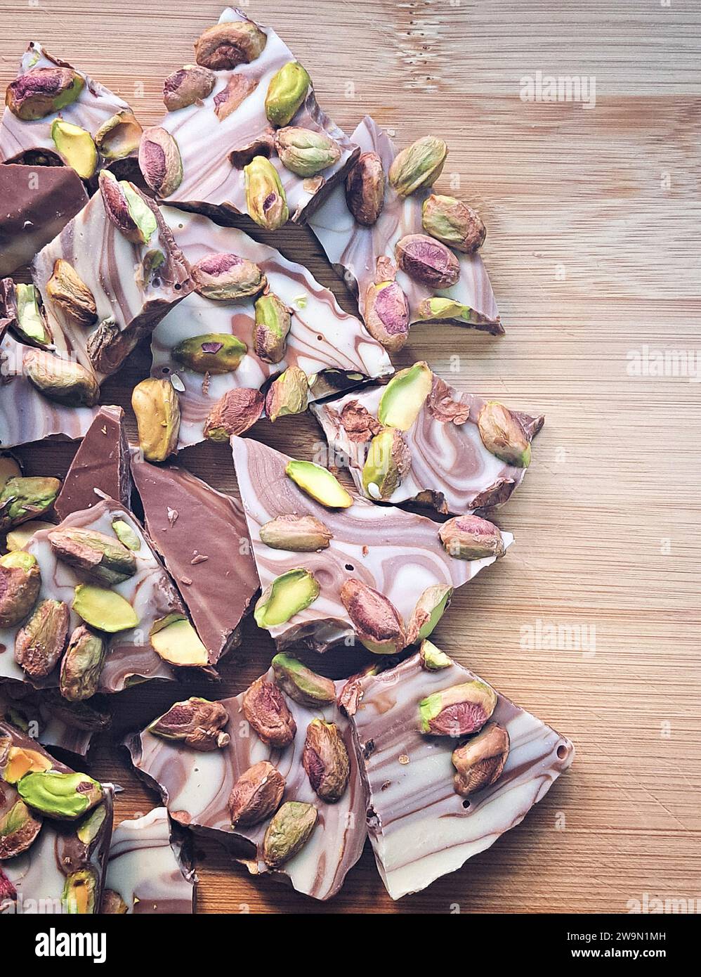 Nahaufnahme von hausgemachten Pistazie- und Schokoladensnacks auf einem Holztisch Stockfoto