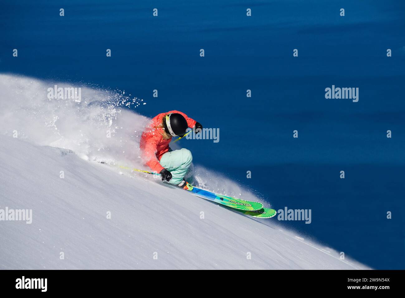 Eine Skifahrerin (Hazel Birnbaum) fährt an einem wunderschönen Tag im Heavenly Mountain Resort mit Lake Tahoe im Hintergrund in der Nähe von South Lake Tahoe, Kalifornien. Stockfoto