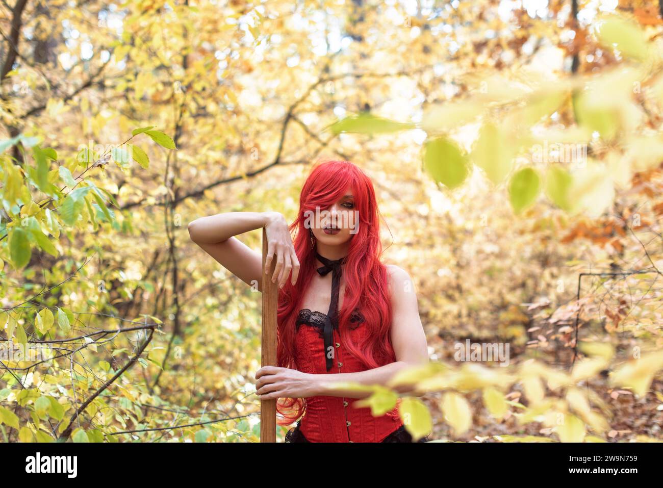 Junge Hexe im Herbstwald Stockfoto