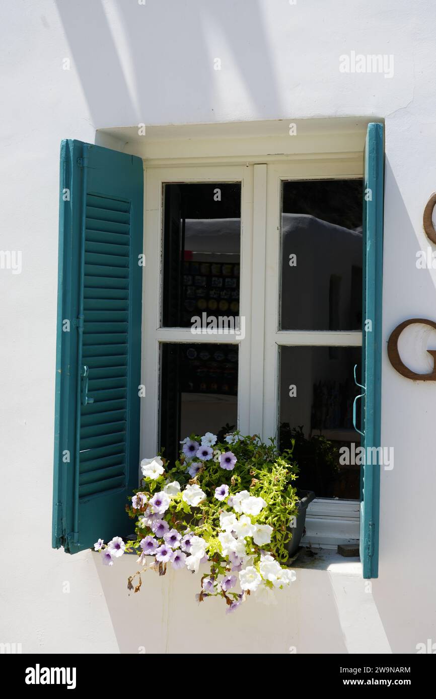 Mediterranes Haus mit einem Fenster mit Fensterläden und einem Blumentopf als Dekoration. Stockfoto
