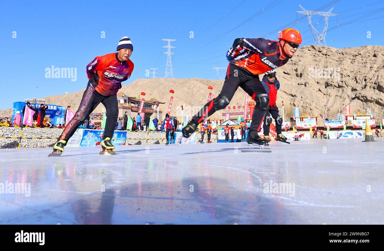 ZHANGYE, CHINA - 29. DEZEMBER 2023 - Eis- und Schneesportbegeisterte fahren auf einem Eis- und Schneesportgelände in der Stadt Zhangye, Provinz Gansu, Stockfoto