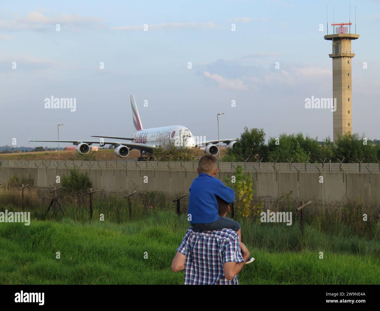 Junge, der eine Emirates A380 beobachtet Stockfoto
