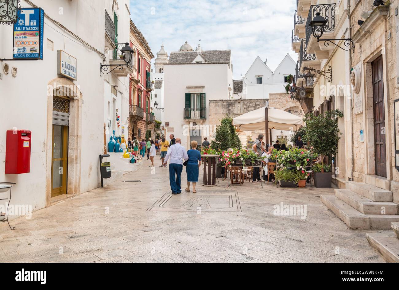 Locorotondo, Apulien, Italien - 5. Oktober 2023: Touristen, die die Restaurants im Freien im alten Dorf Locorotondo in der Provinz Bari genießen. Stockfoto