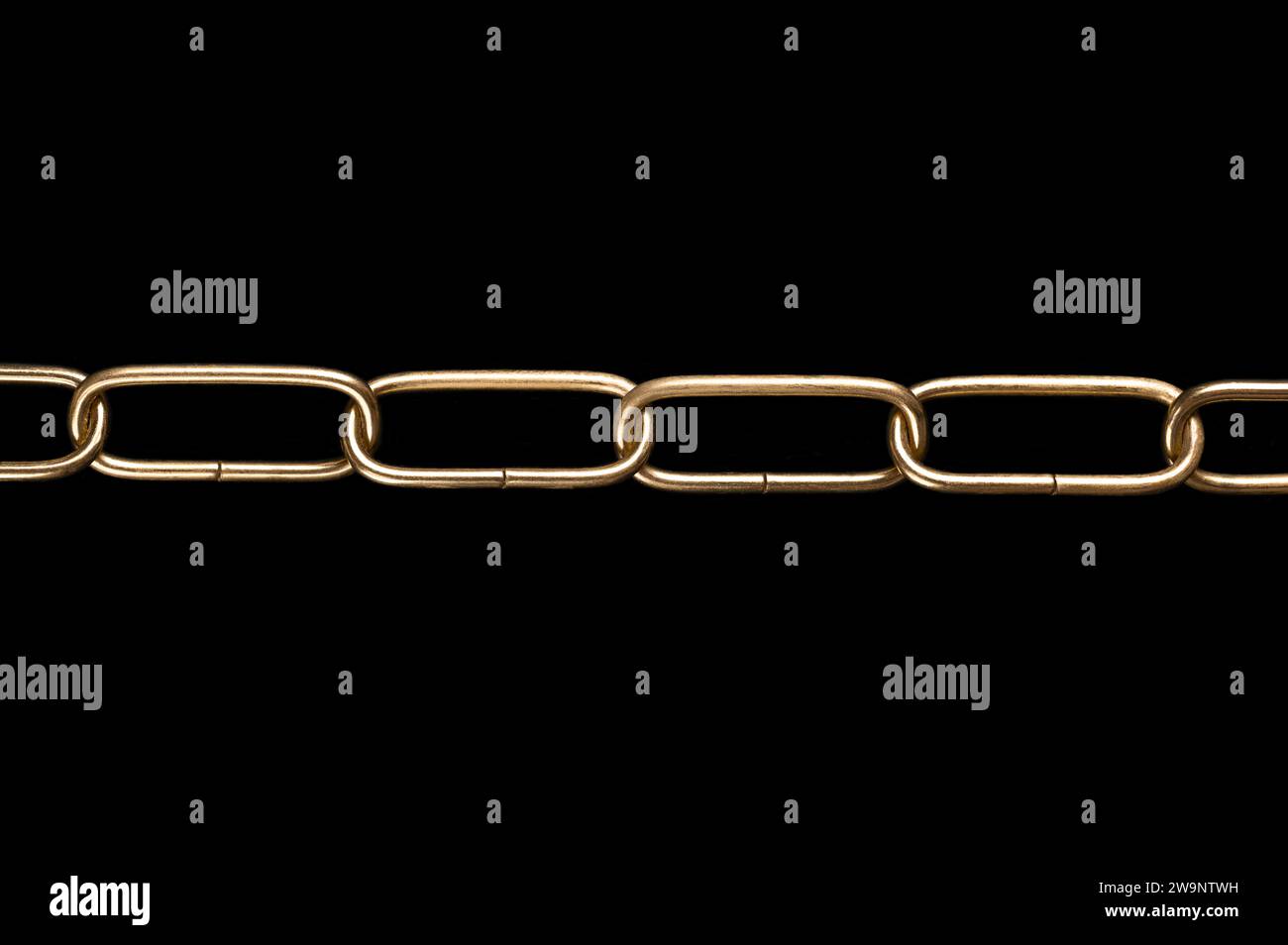 Stahlkette mit glänzender, vermessingter Oberfläche, gerade Form, mit abgerundeten Gliedern, über schwarz. Glatte und dekorative Ringkette aus Runddraht. Stockfoto