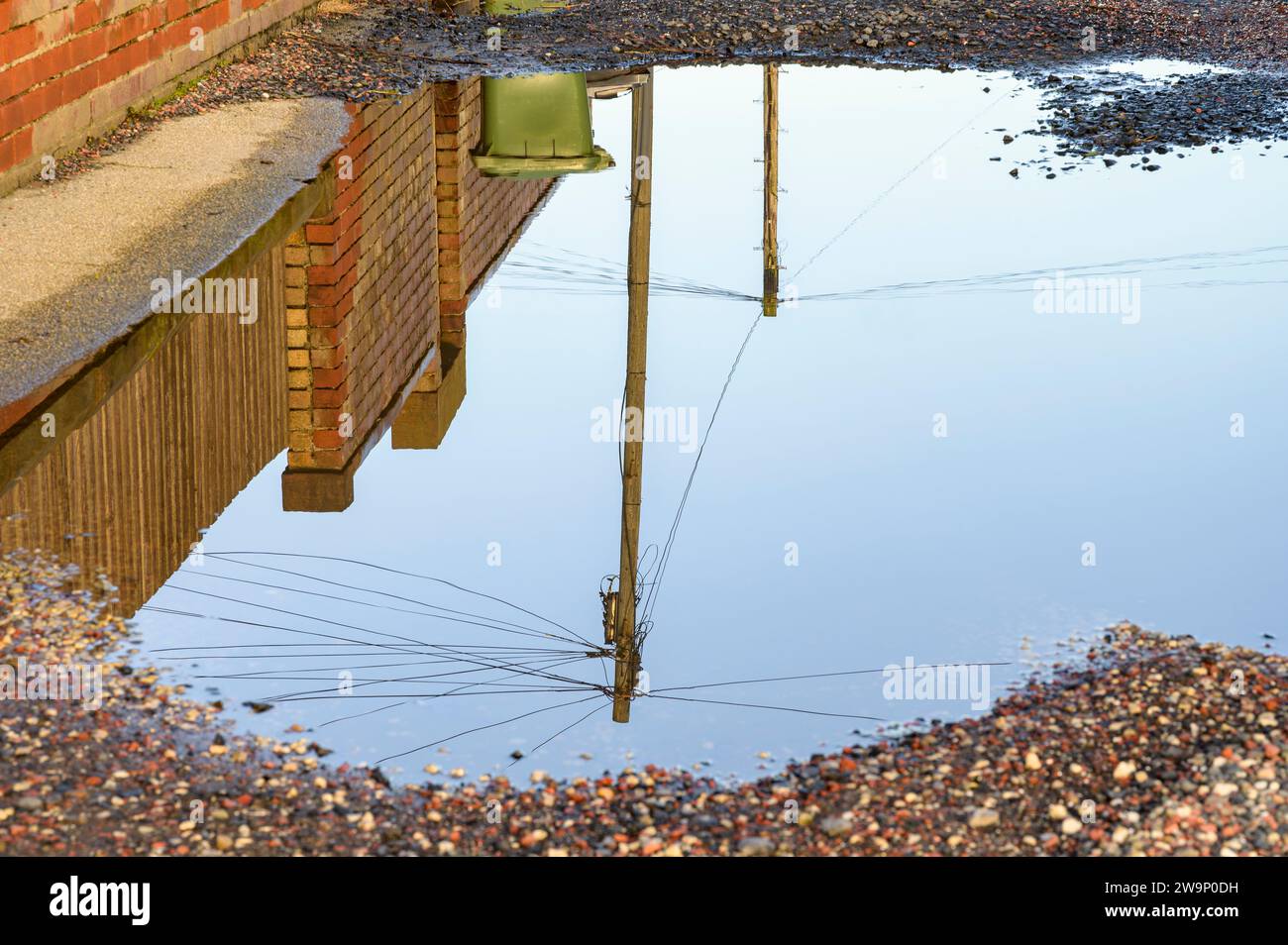 Eine große Pfütze in einer Gasse, Großbritannien Stockfoto