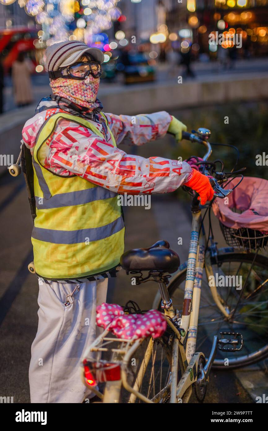 Ein maskierter Skateboarder und ihr Fahrrad in London. Stockfoto