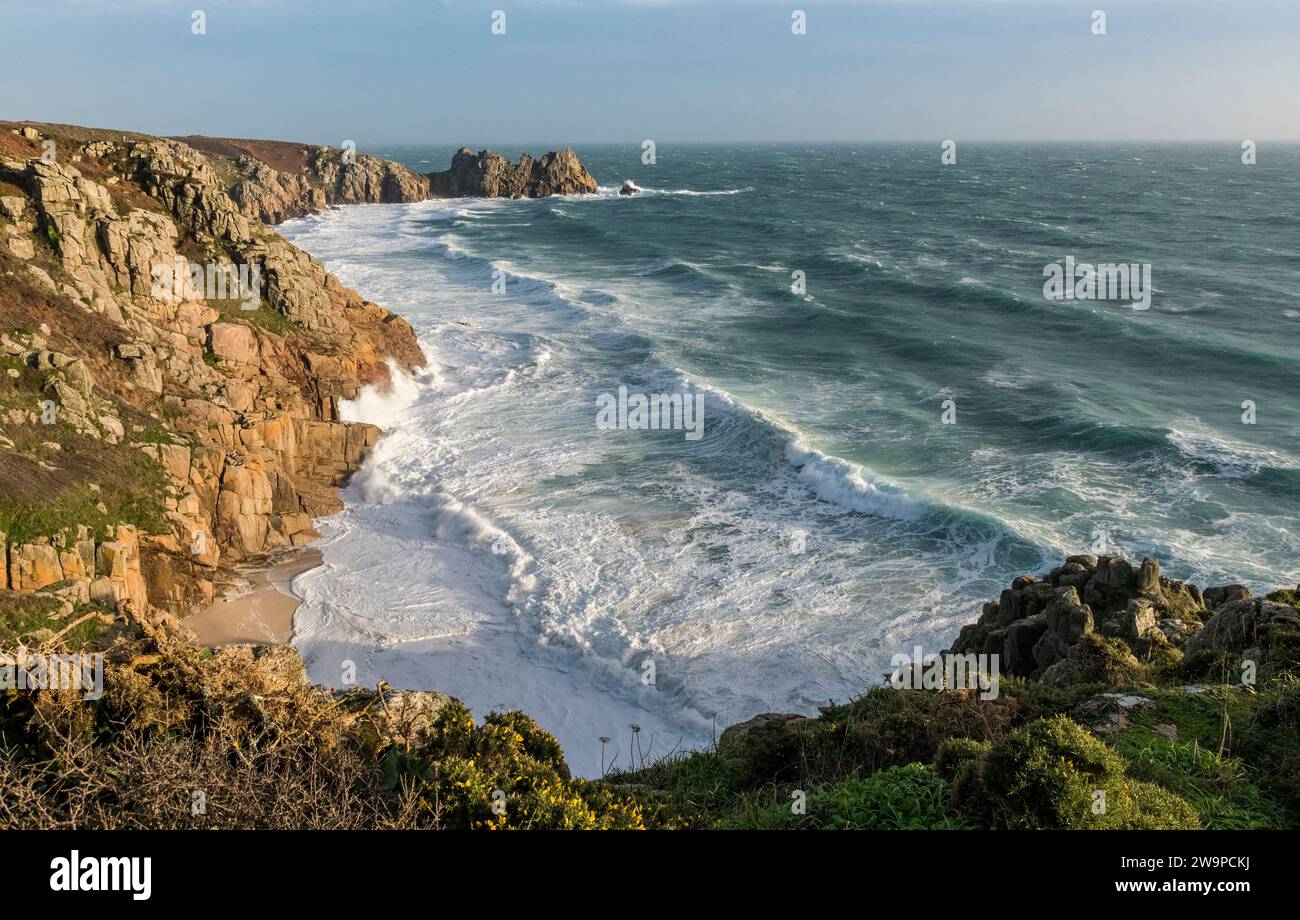 Raue See bricht über den Pedn Vounder Beach in Cornwall, als Storm Gerrit zu Weihnachten 2023 durch den Strand zieht. Der Logan Rock ist im Hintergrund Stockfoto