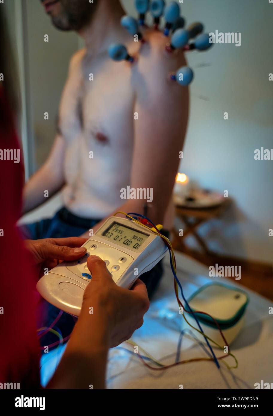 Health Care Akupunktur Konzept, Ein Mann wird mit Akupunktur elektrische Stimulationsbehandlung behandelt, um Körper Muskel zu entspannen, Maschine für Elektrode P Stockfoto