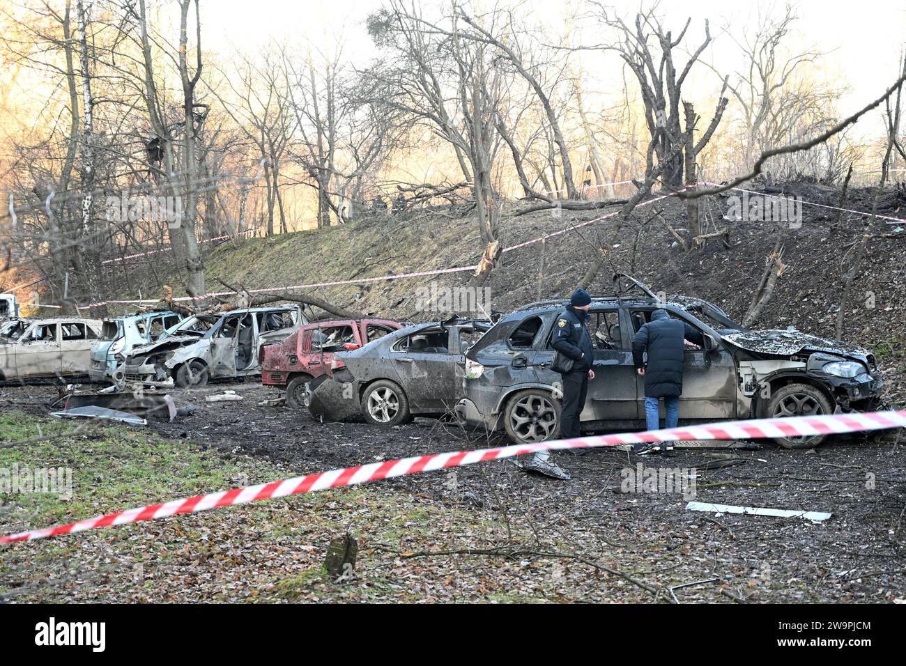 Lemberg, Ukraine - 29. Dezember 2023: Zerstörte Privatfahrzeuge am Ort eines russischen Raketenangriffs in Lemberg. Stockfoto