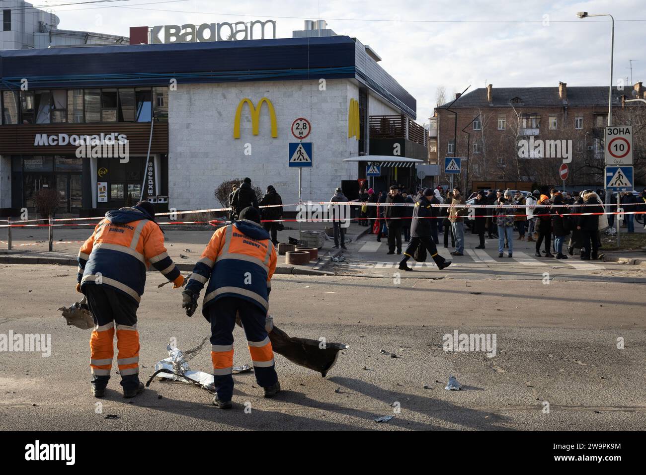 Kiew, Ukraine. Dezember 2023. Kommunale Arbeiter sammeln am Ort einer russischen Raketenexplosion in Kiew Trümmer von Gebäudefassaden und zerstörten Autos. Quelle: SOPA Images Limited/Alamy Live News Stockfoto