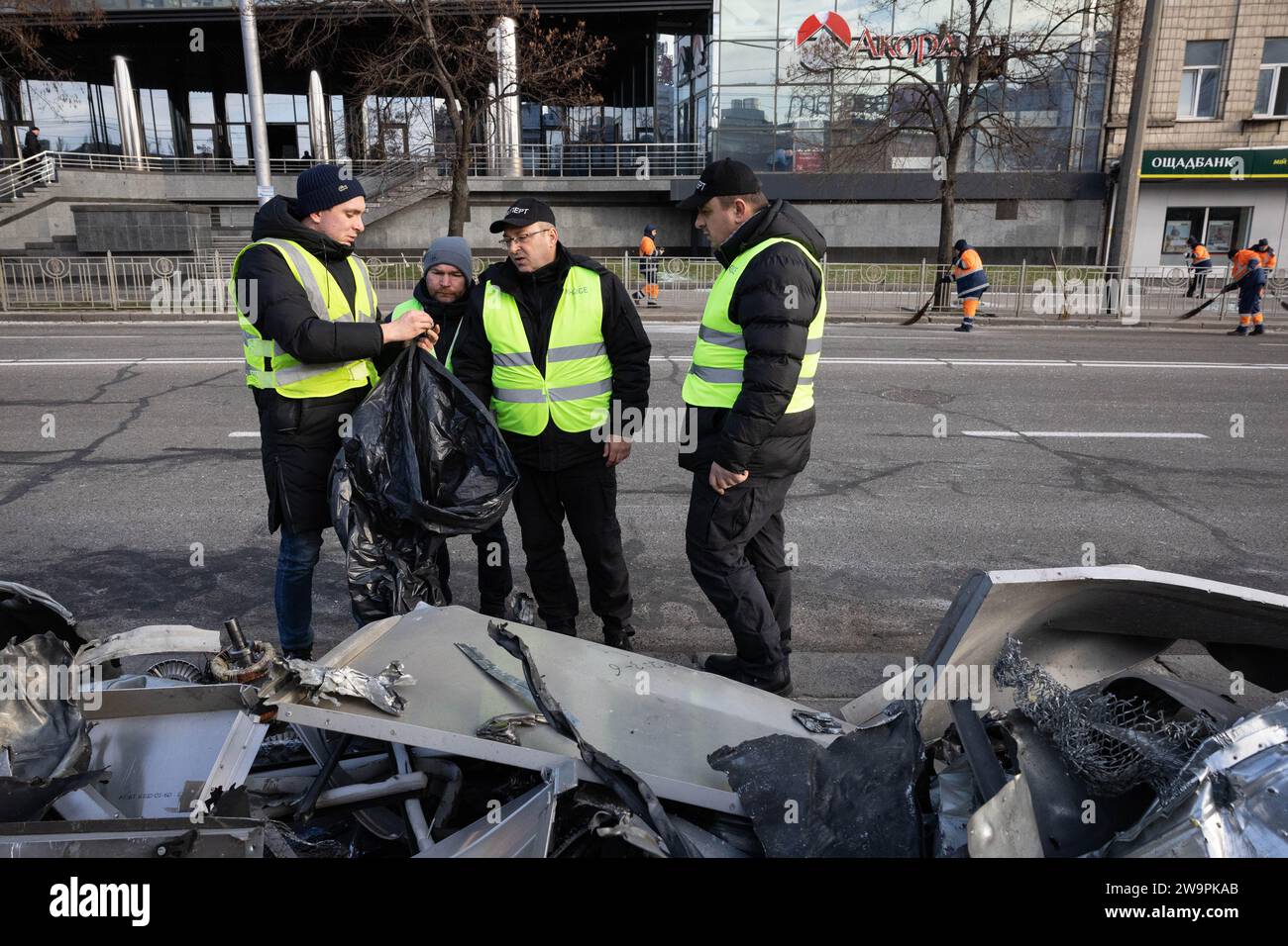 Kiew, Ukraine. Dezember 2023. Polizeibeamte untersuchen Trümmer von Gebäudefassaden und zerstörte Autos am Ort einer russischen Raketenexplosion in Kiew. Quelle: SOPA Images Limited/Alamy Live News Stockfoto