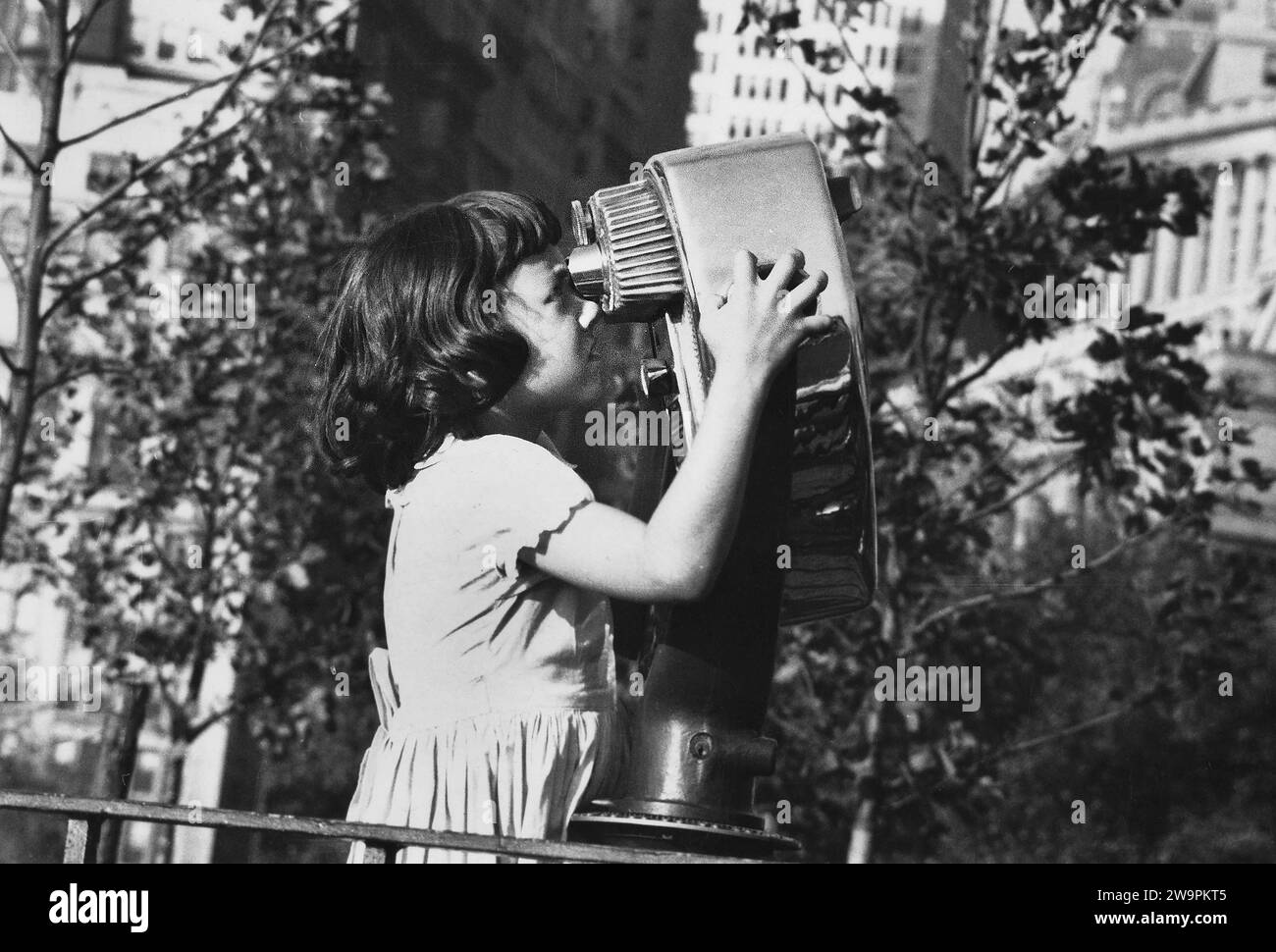 Junges Mädchen, das durch Münzferngläser schaut, New York City, New York, USA, Angelo Rizzuto, Anthony Angel Kollektion Stockfoto