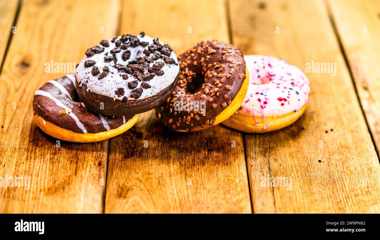 Bunte Donuts auf Holztisch. Süße Puderzuckernahrung mit glasierten ...