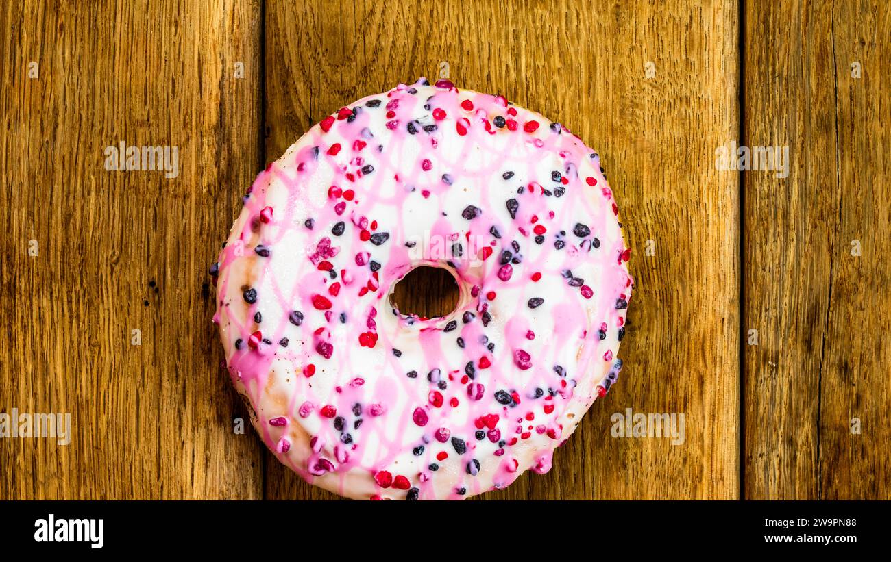 Bunte Donuts auf Holztisch. Süße Puderzuckernahrung mit glasierten ...