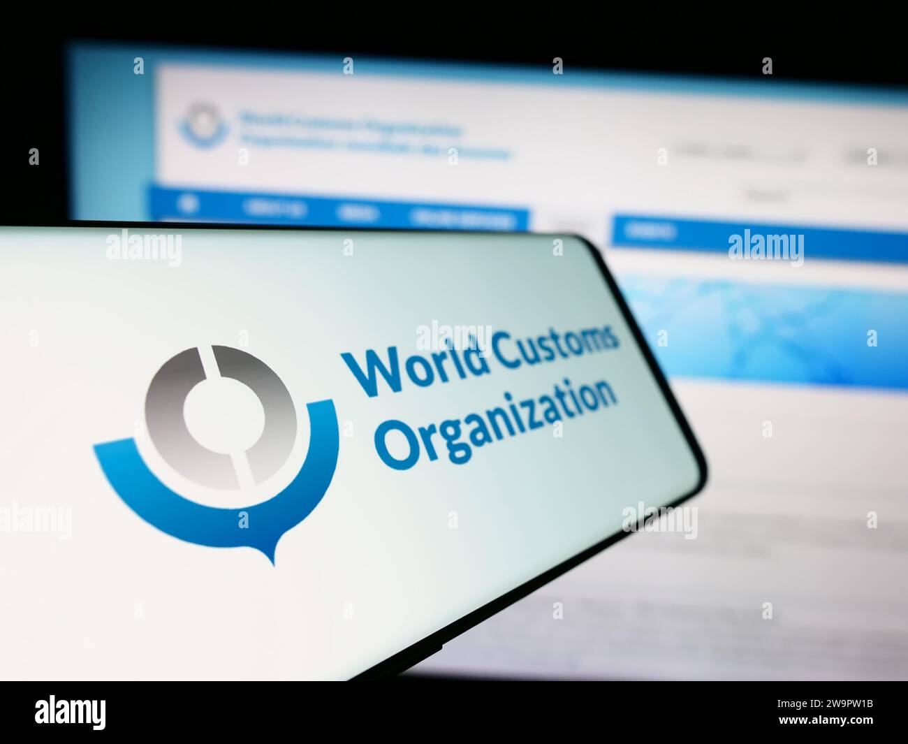 Mobiltelefon mit Logo der Weltzollorganisation (WZO) vor der Website. Fokus auf der linken Seite des Telefondisplays. Stockfoto