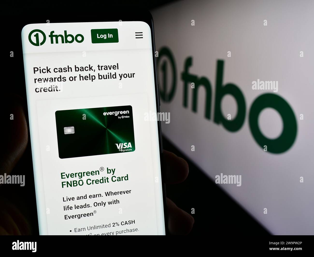 Person mit Smartphone und Webseite des US-Finanzunternehmens First National Bank Omaha (FNBO) mit Logo. Konzentrieren Sie sich auf die Mitte des Telefondisplays. Stockfoto