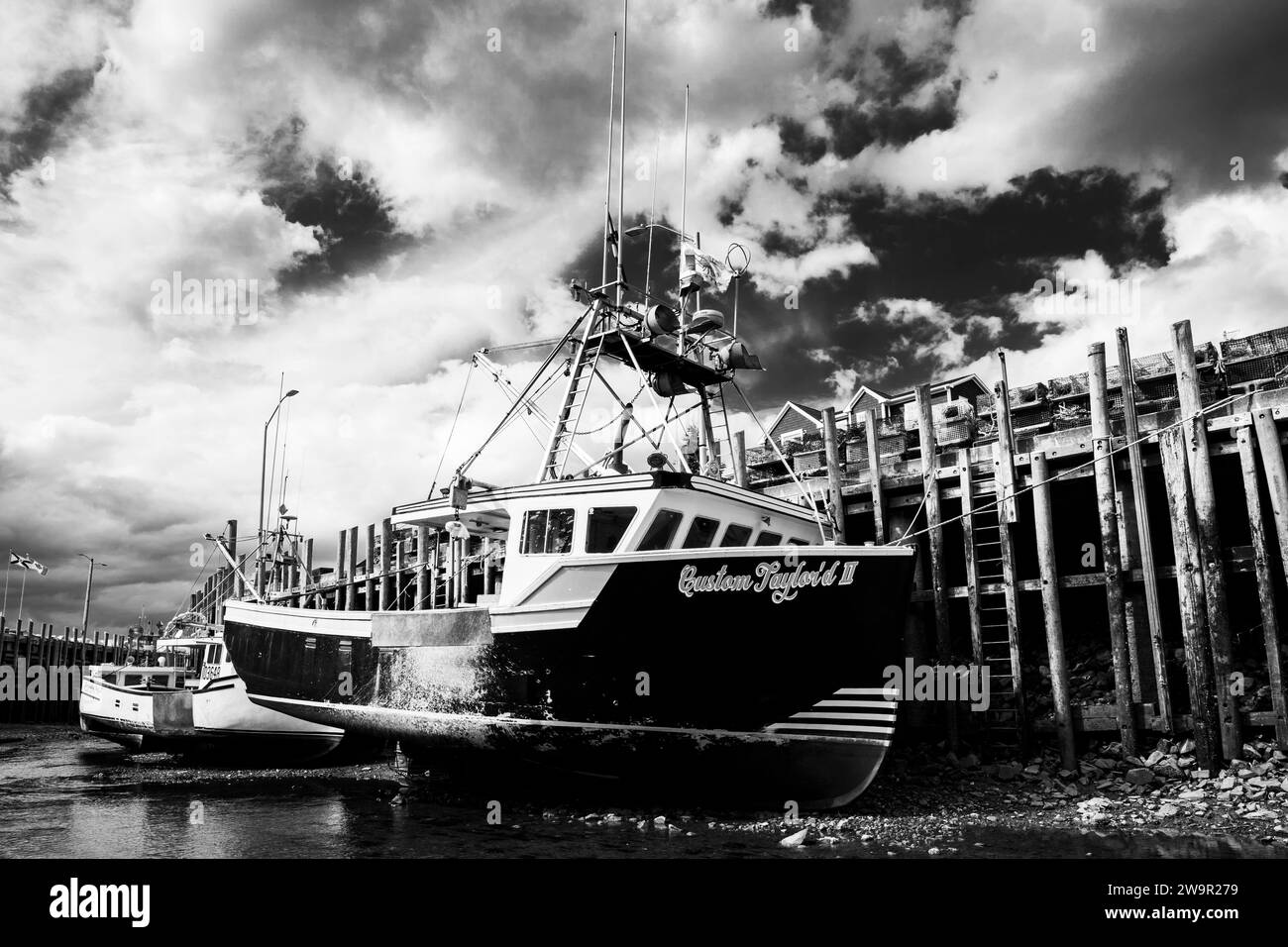 Fischerboote bei Ebbe an einem Pier in Halls Harbour, Nova Scotia, Kanada. Stockfoto