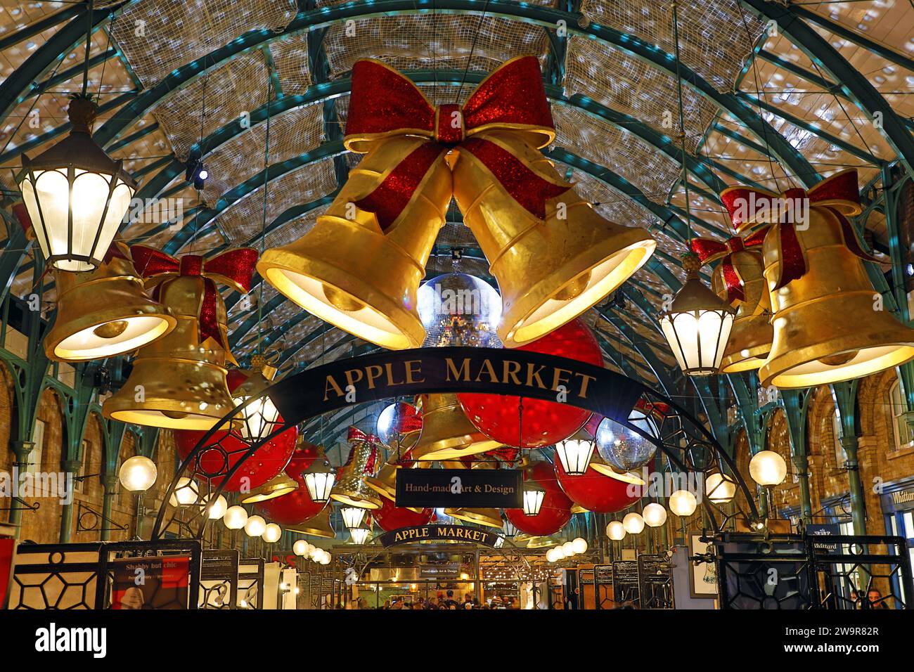 Weihnachtsbeleuchtung im Covent Garden Market in London 2023 in Form von Glocken und Bändern Stockfoto