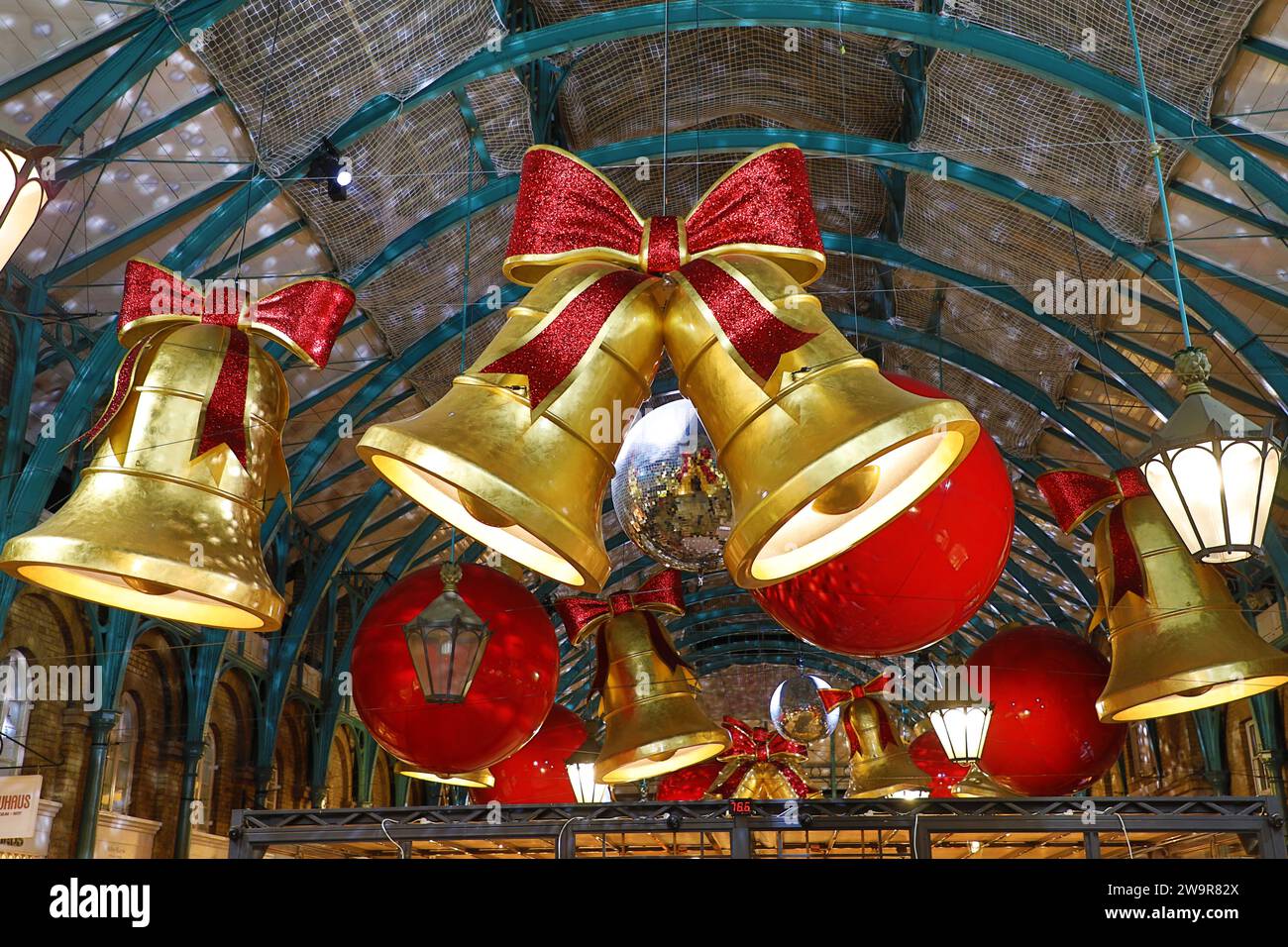 Weihnachtsbeleuchtung im Covent Garden Market in London 2023 in Form von Glocken und Bändern Stockfoto