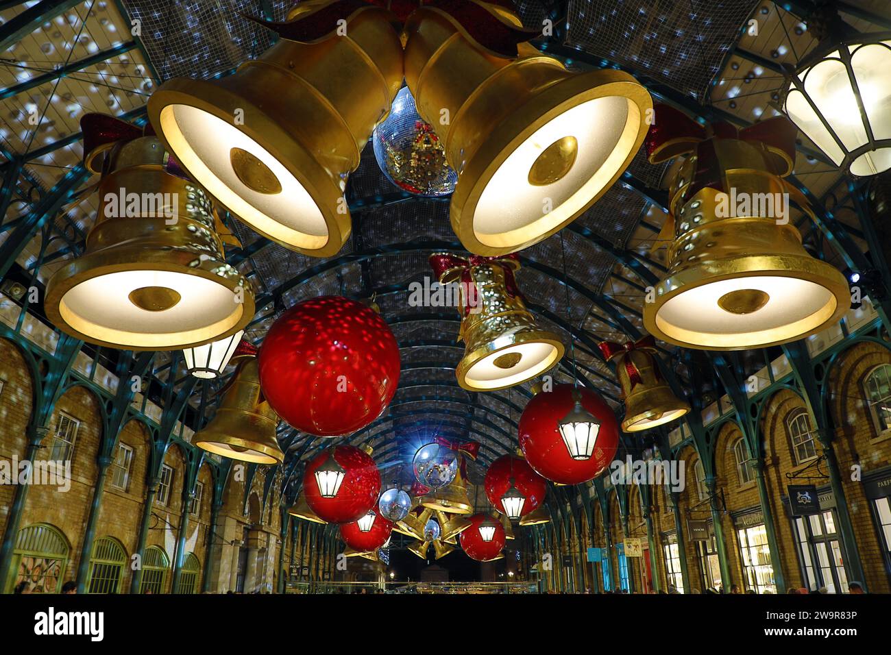 Weihnachtsbeleuchtung im Covent Garden Market in London 2023 in Form von Glocken und Bändern Stockfoto