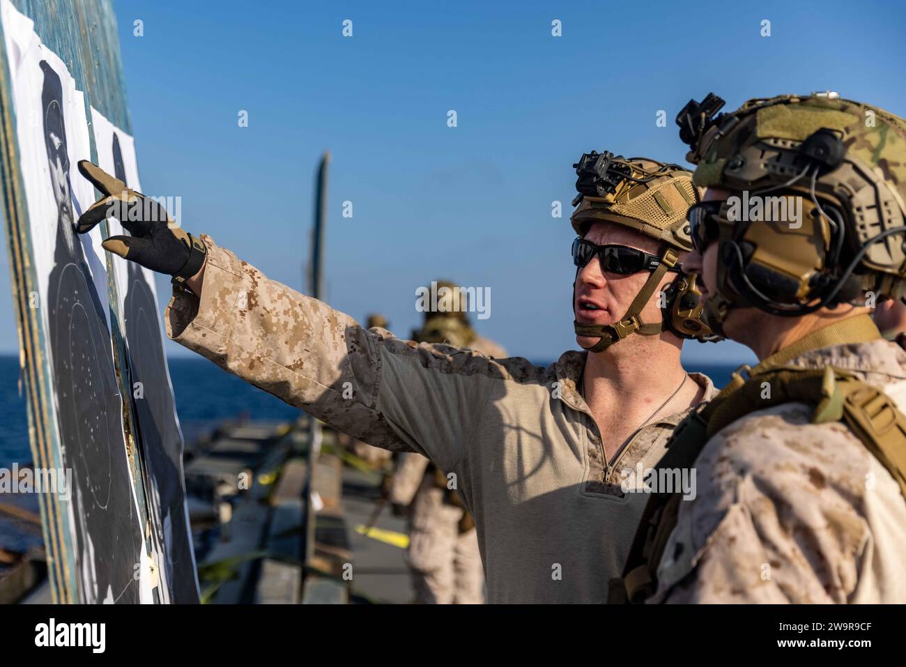 231215-M-GH793-1256 5. EINSATZGEBIET DER FLOTTE (15. Dezember 2023) U.S. Marine Corps First Lt. Claude Macari (links), ein Zugkommandant, und CPL. Lucas Bosin (rechts), ein Schützling mit Bataillon Landing Team 1/6, 26. Marine Expeditionary Unit (Special Operations Capable), überprüft die Schussplatzierung während eines Live-Feuertrainings an Bord des Dock-Landungsschiffes USS Carter Hall (LSD 50). Die 26th Marine Expeditionary Unit (Special Operations Capable), die auf den Schiffen der Bataan Amphibious Ready Group eingestiegen ist, wird als Tri-Geographic Combatant Command Crisis Response Forc eingesetzt Stockfoto