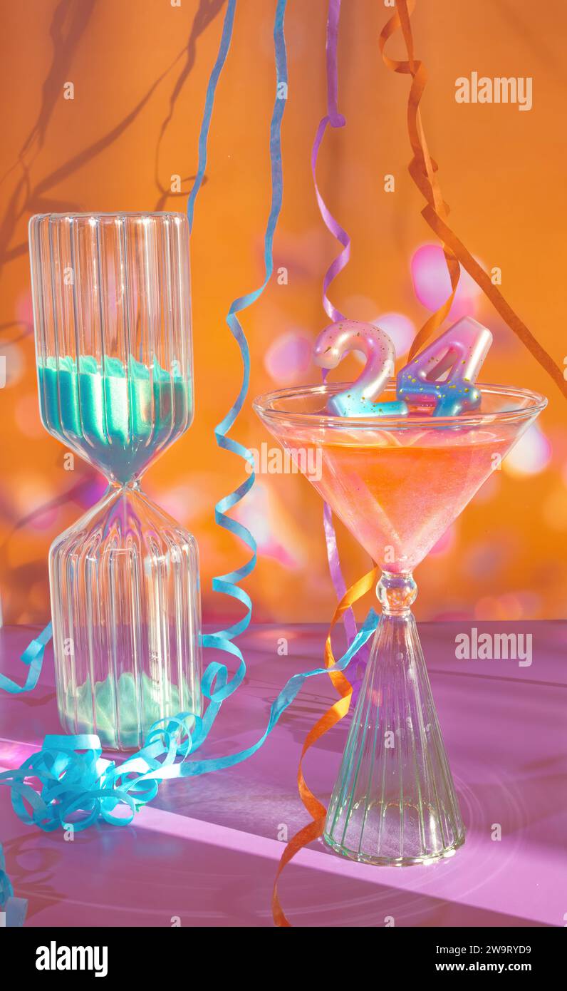 Countdown bis zum 24. Geburtstag, Sand Timer Countdown bis 2024, 24. Jahrestag, Zahlen 24 in einem Martini Glas in einer Partyszene mit dekorierten Streamers und Stockfoto