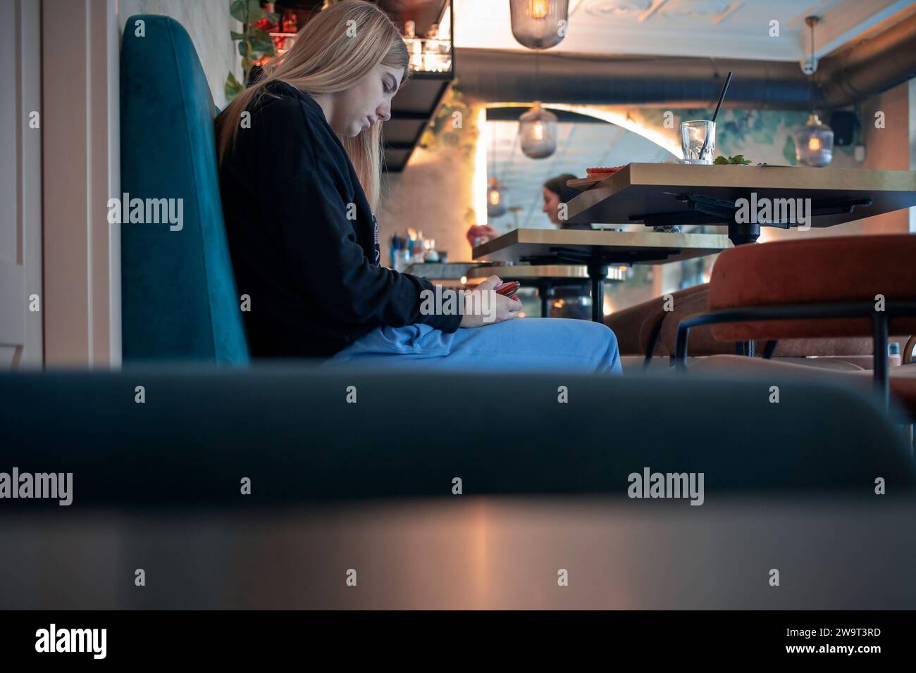 Belgrad, Serbien, 4. Dezember 2023: Eine junge Frau sitzt und schreibt in einem der Cafés in der Innenstadt Stockfoto
