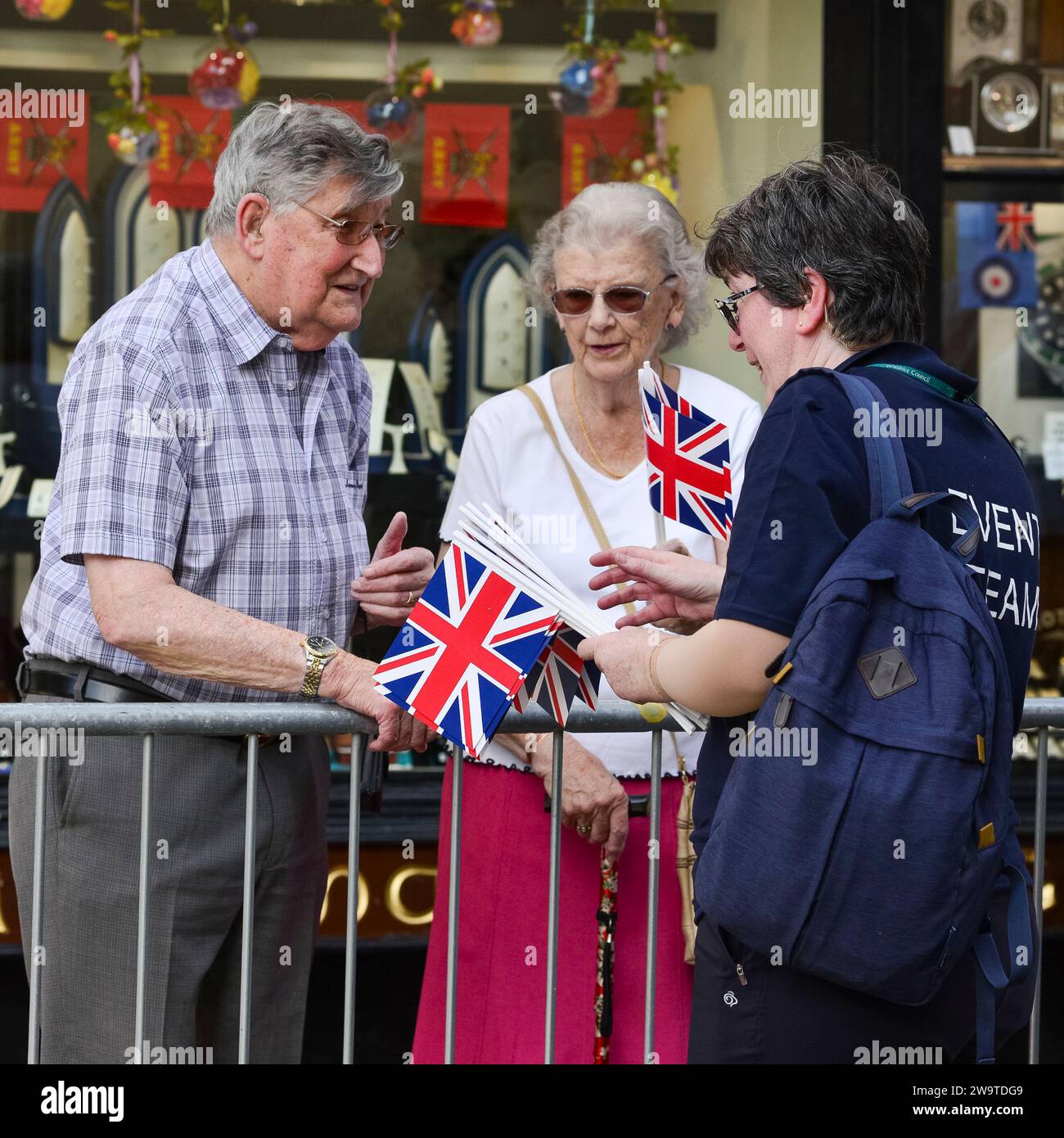Seniorenpaar erhält Union Jack Flaggen von einem Organisator beim Armed Forces Day, Salisbury, Großbritannien, 2019 Stockfoto