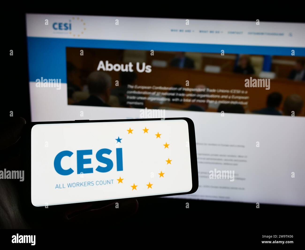 Person mit Smartphone und Logo des Europäischen Gewerkschaftsbundes (CESI) vor der Website. Schwerpunkt auf dem Display des Telefons. Stockfoto