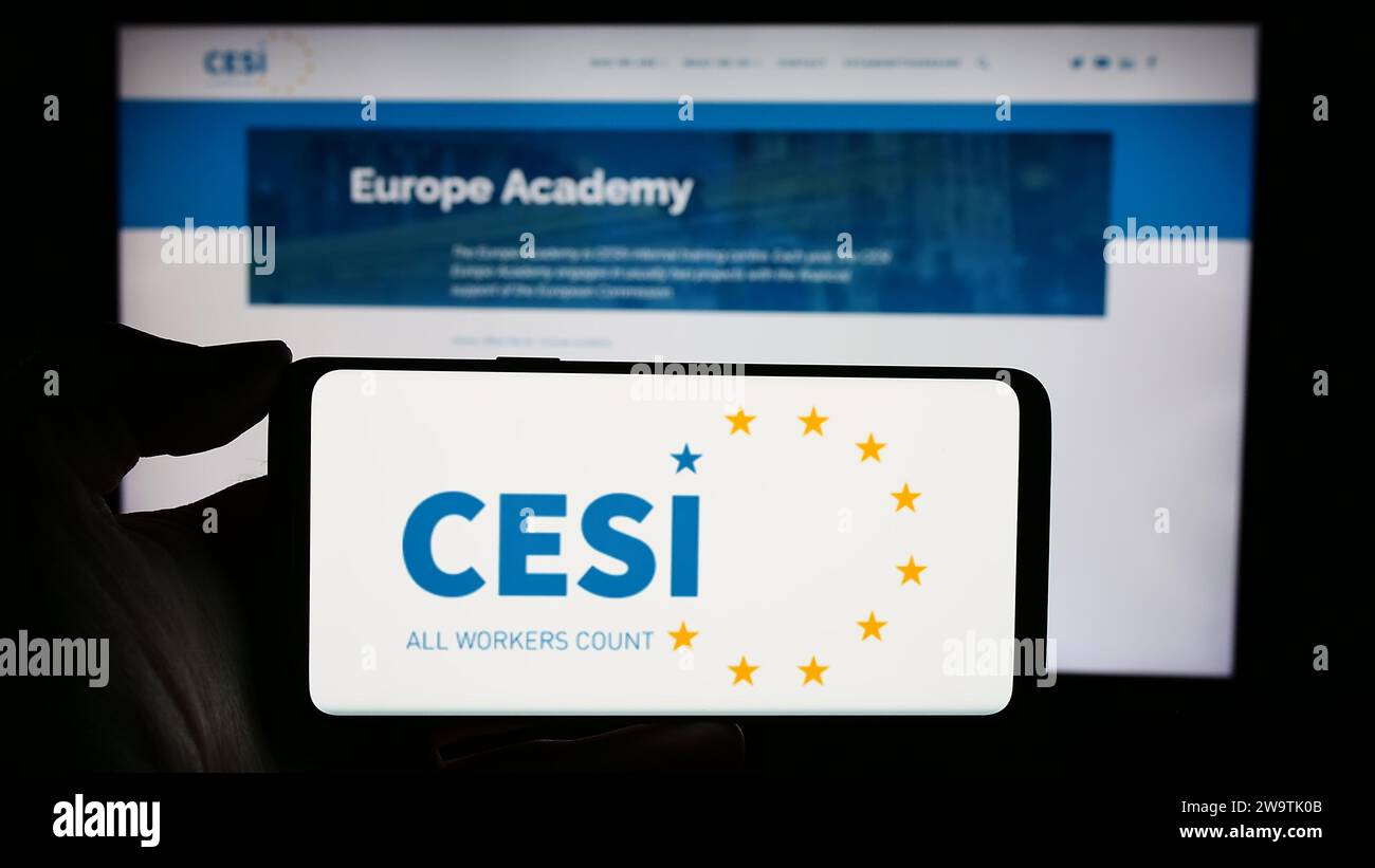 Person, die ein Mobiltelefon mit dem Logo des Europäischen Gewerkschaftsverbands (CESI) vor der Webseite hält. Schwerpunkt auf dem Display des Telefons. Stockfoto