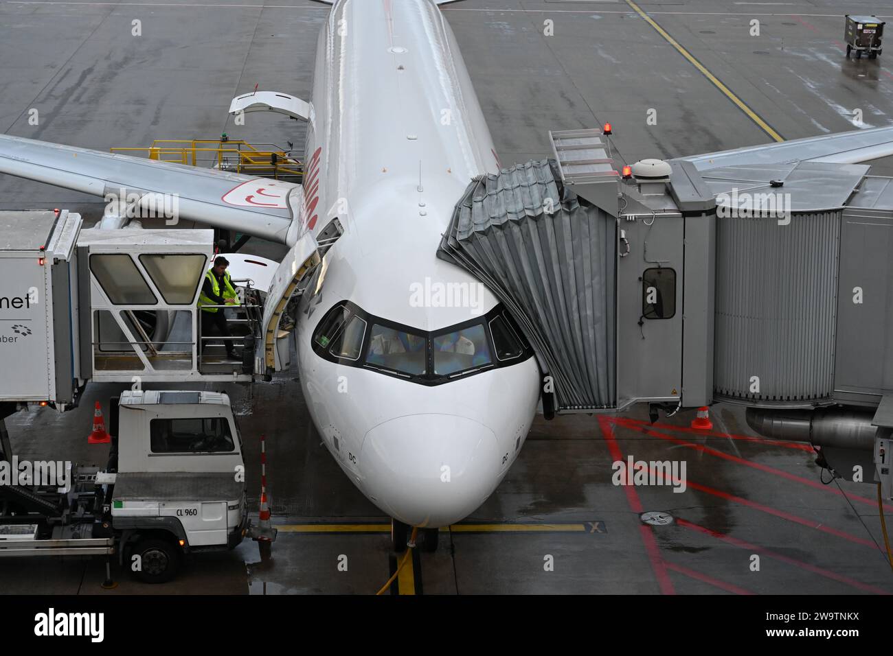 Weißes Flugzeug mit ausziehbarem Arm oder Anschluss für die Einschiffung des Passagiers. Stockfoto