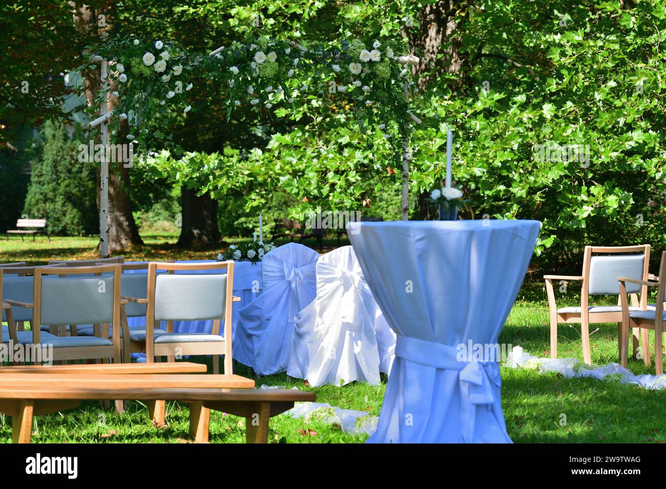 Dekorierter Hochzeitsaltar bei einer Hochzeit im Freien in einem Gartenpark mit weißen Stühlen Stockfoto