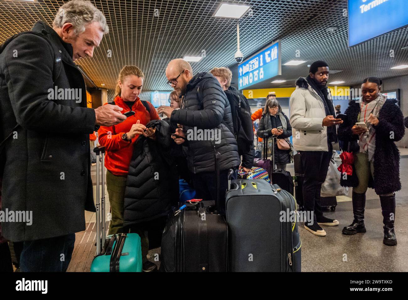 Brüssel, Belgien Dezember 2023 30. Leute (viele sind verärgert und versuchen vergeblich, Hilfe von den Angestellten zu bekommen) kommen am Midi-Terminal in Brüssel an, um Züge nach London St Pancras zu nehmen und werden von Absagen und Angestellten begrüßt, die wenig Informationen haben. Kurz nach Weihnachten und im Vorfeld des Neujahrs bricht Eurostar alle Züge von Brüssel nach London ab, was durch Überschwemmungen in einem Tunnel in Großbritannien zustande kommt. Kurz vor Weihnachten kam es zu erheblichen Störungen, die auch zu Annullierungen und erheblichen Verzögerungen führten. Guy Bell/Alamy Live News Stockfoto