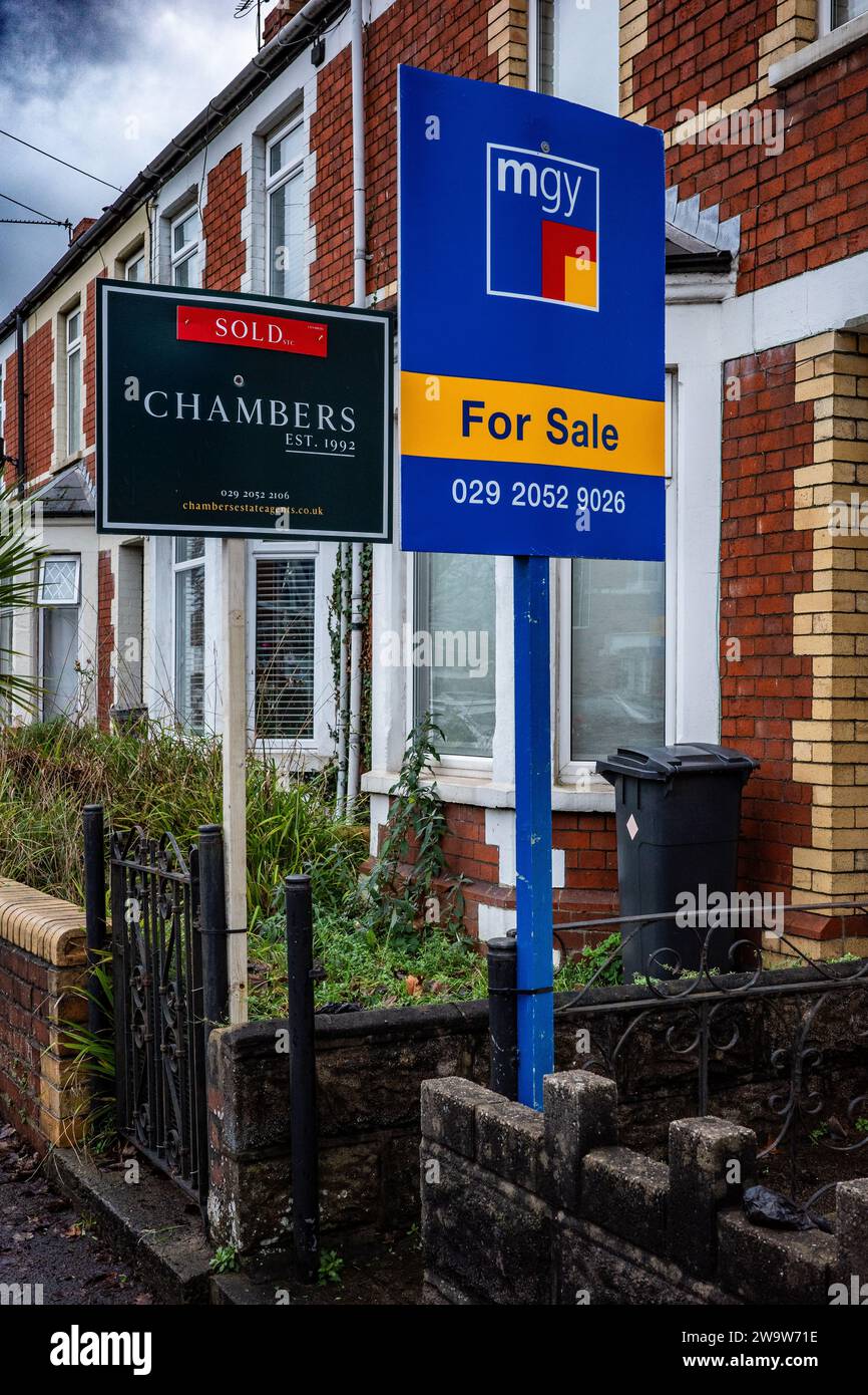 Immobilienmakler zum Verkauf und Verkaufszeichen in einer Reihe von britischen Häusern. Immobilienmarkt, Wohnungsmarkt, Wirtschaft. Hypotheken. Finanzen. Stockfoto