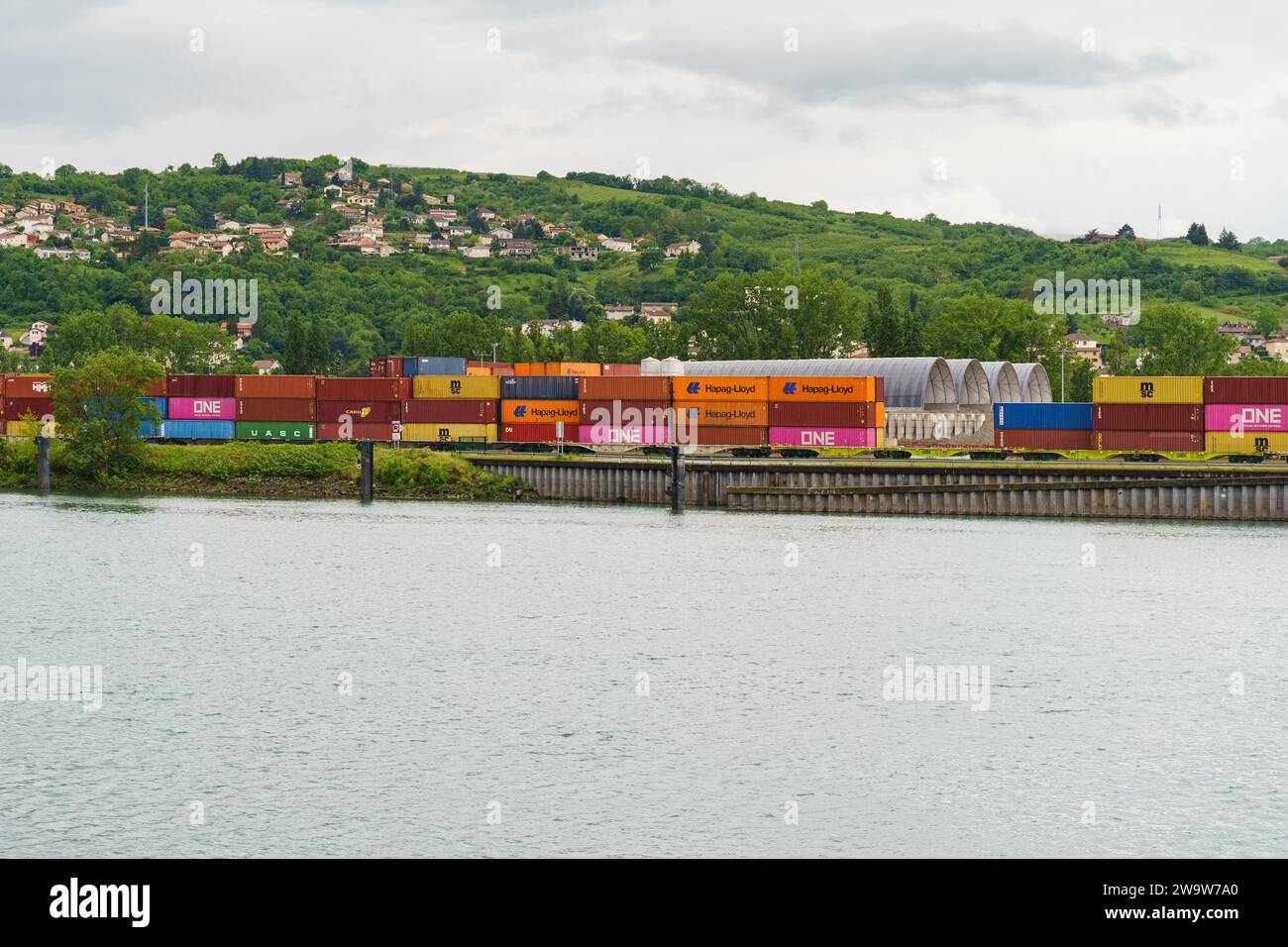 Lyon, Frankreich - 7. Mai 2023: Frachtcontainer am Eisenbahncontainer-Terminal in der Nähe des Flusses. Internationale Frachtlogistik Stockfoto