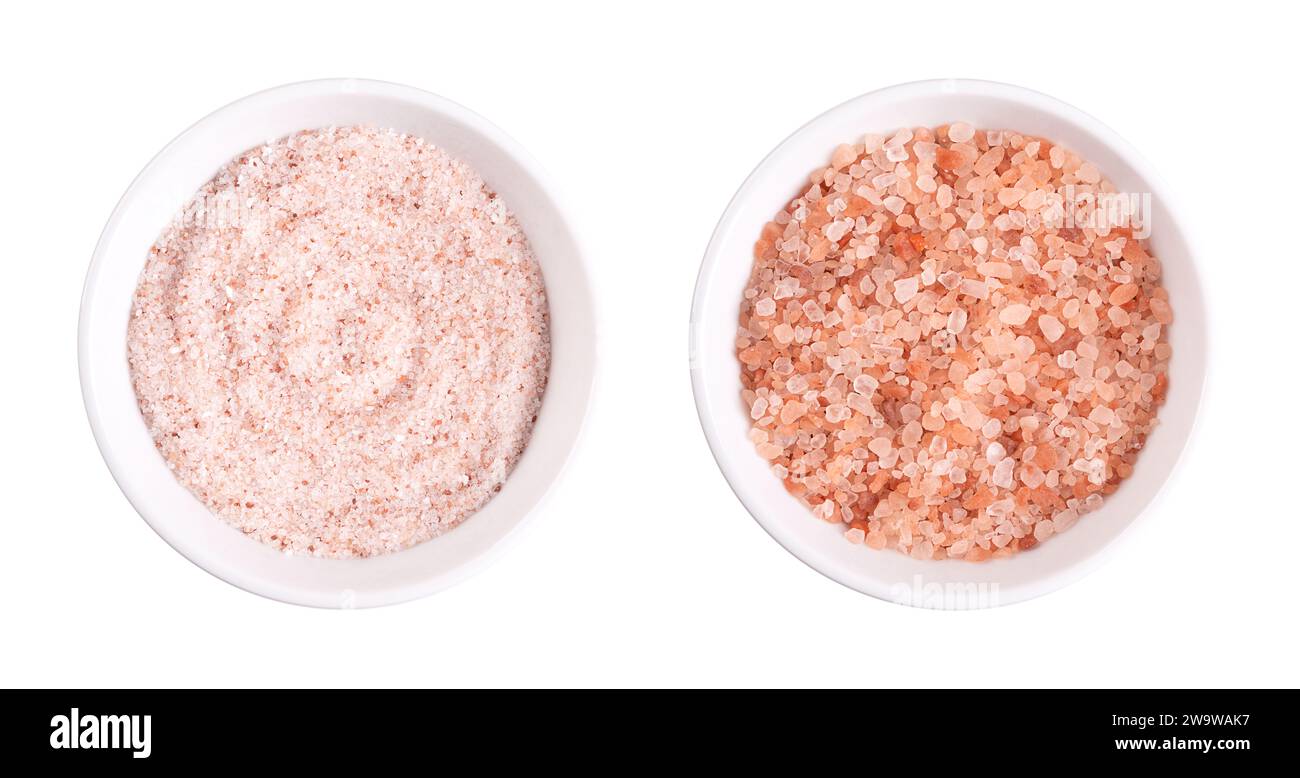 Himalaya rosa Salz, fein und grob, in weißen Schüsseln. Feines Himalaya-Salz, Steinsalz und Halit mit rosafarbener Färbung aufgrund von Spurenelementen. Stockfoto