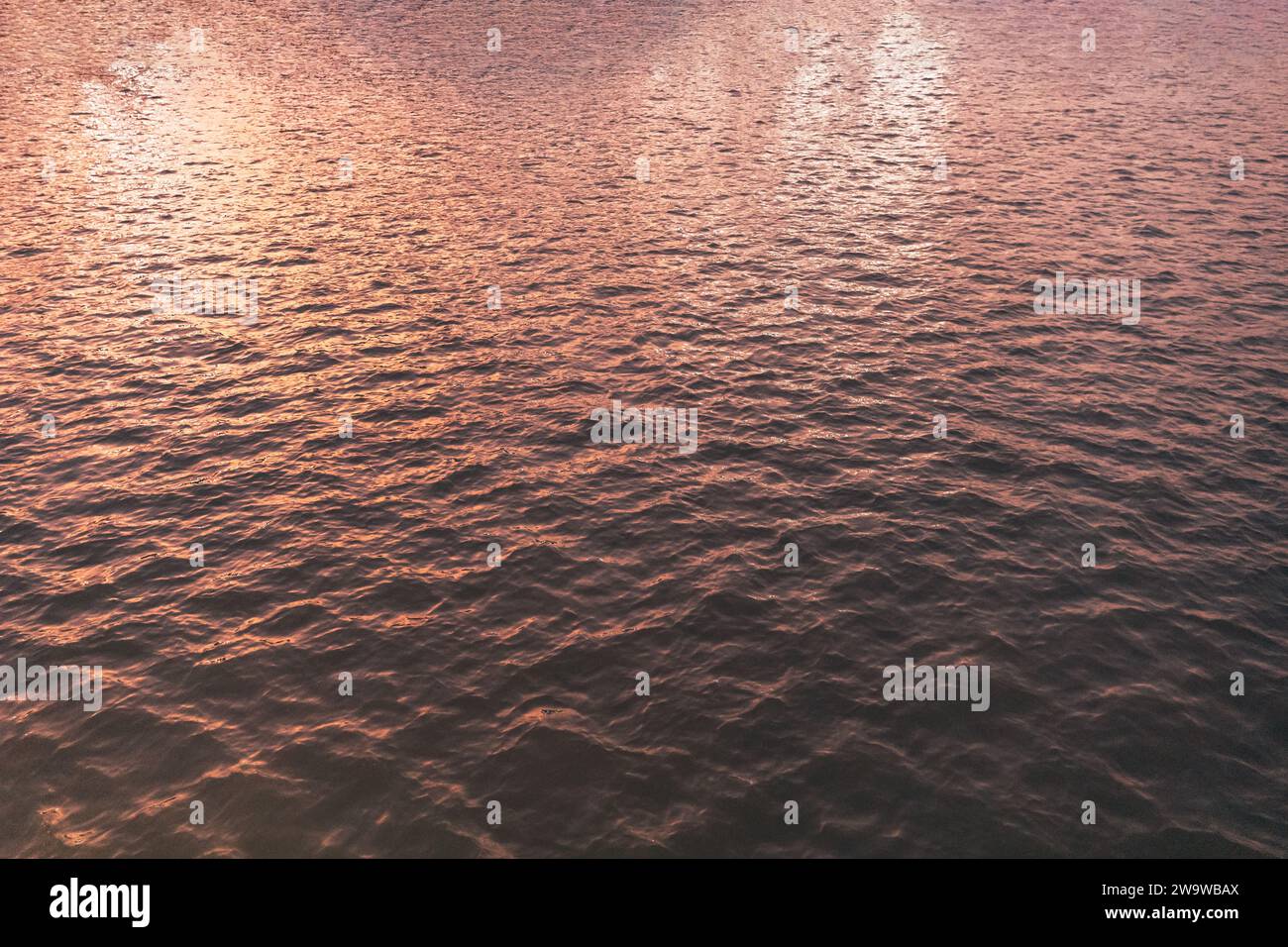Textur der Wasseroberfläche, Sonnenaufgang. Am Morgen Meer aus nächster Nähe romantischer wunderschöner Hintergrund. Detaillierte Nahansicht von Wasseroberflächen mit WAV Stockfoto