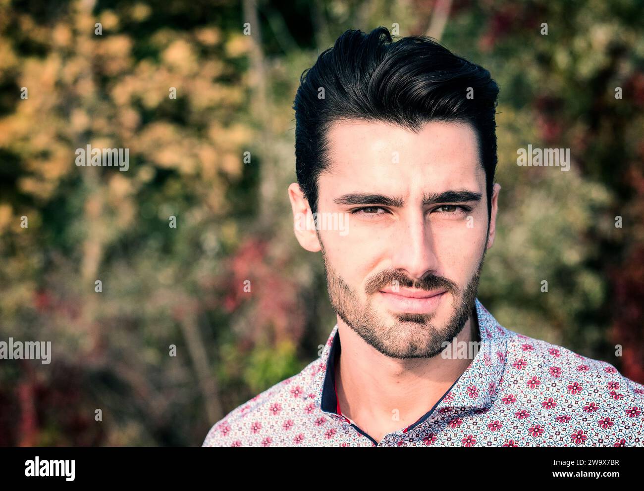 Eine Nahaufnahme eines jungen attraktiven Mannes, der ein Hemd trägt und in die Kamera schaut. Kopfschuss Stockfoto