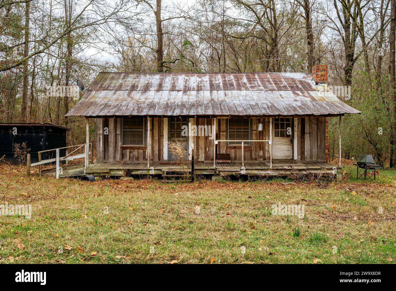 Alte verlassene rustikale Pionier Holzhütte mit überdachter Veranda im ländlichen Alabama, USA. Stockfoto