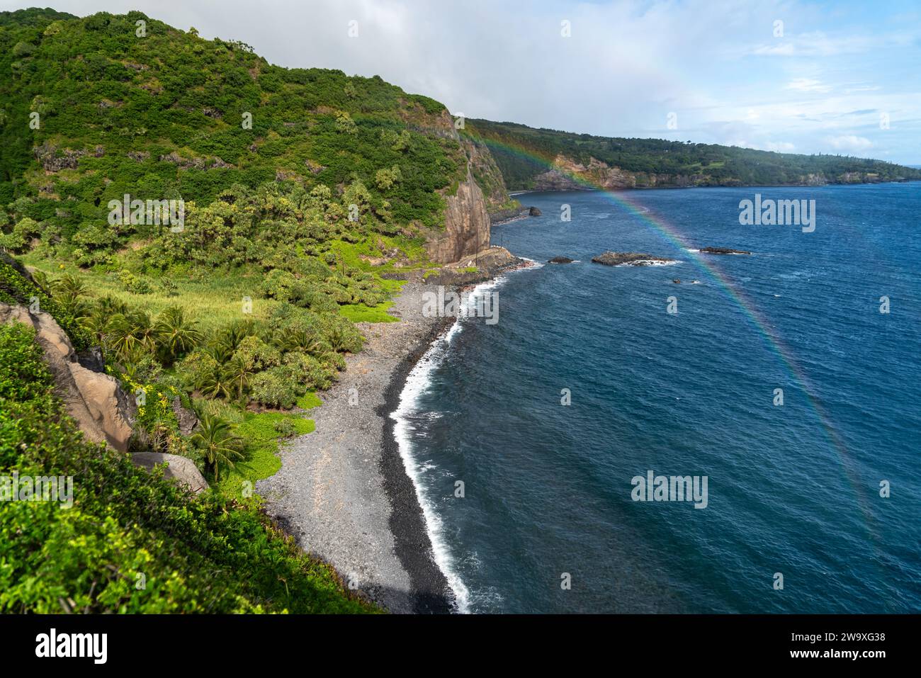 Dieser abgeschiedene schwarze Sandstrand, umgeben von üppigem tropischem Grün und Lavasteinen, ist ein ruhiger Ort an Mauis Südküste in der Nähe des Piilani Highway. Stockfoto