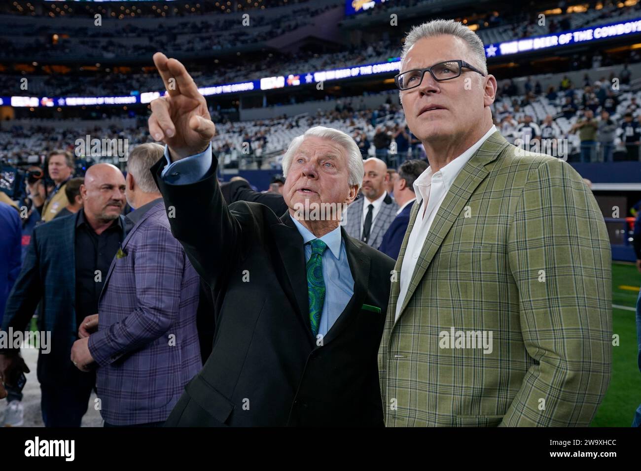 Pro Football Hall of Fame coach Jimmy Johnson, left, talks with former NFL player Howie Long prior to an NFL football game between the Dallas Cowboys and the Detroit Lions, Saturday, Dec. 30, 2023, in Arlington, Texas. Johnson will be inducted into the team's ring of honor during a halftime ceremony. (AP Photo/Sam Hodde) Stockfoto