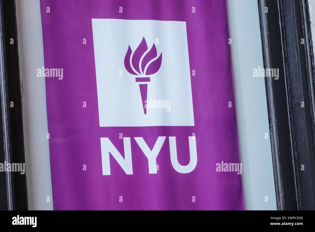 New York, USA. Dezember 2023. Ein Logo der New York University ist vor einem Gebäude des Campus zu sehen. Die New York University (NYU) ist eine renommierte private Forschungsuniversität im Herzen von New York City, bekannt für ihr vielfältiges und dynamisches akademisches Umfeld. Die NYU blickt auf eine reiche Geschichte zurück, die bis ins Jahr 1831 zurückreicht und aus mehreren Schulen, Colleges und Instituten besteht, die eine breite Palette an Bachelor-, Graduiertenprogrammen und professionellen Programmen in verschiedenen Disziplinen wie Kunst, Wissenschaft, Wirtschaft, Recht und mehr anbieten. Der städtische Campus und globale Outreach-Initiativen bieten Studenten Stockfoto