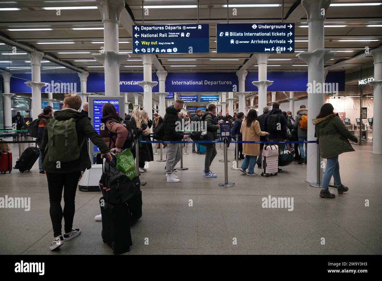 Passagiere stehen am Eingang zum Eurostar in der St Pancras International Station im Zentrum von London an. Eurostar hat angekündigt, dass alle seine Dienste am Sonntag wieder aufgenommen werden, nachdem die Überschwemmungen in Tunneln unter der Themse unter Kontrolle gebracht wurden, obwohl Geschwindigkeitsbeschränkungen zu Verzögerungen führen können. Bilddatum: Sonntag, 31. Dezember 2023. Stockfoto