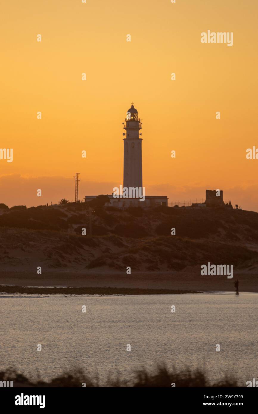 Der Leuchtturm am Strand mit einem klaren Sonnenuntergang. Der Leuchtturm befindet sich in der Küstenstadt Caños de Meca in Südspanien Stockfoto
