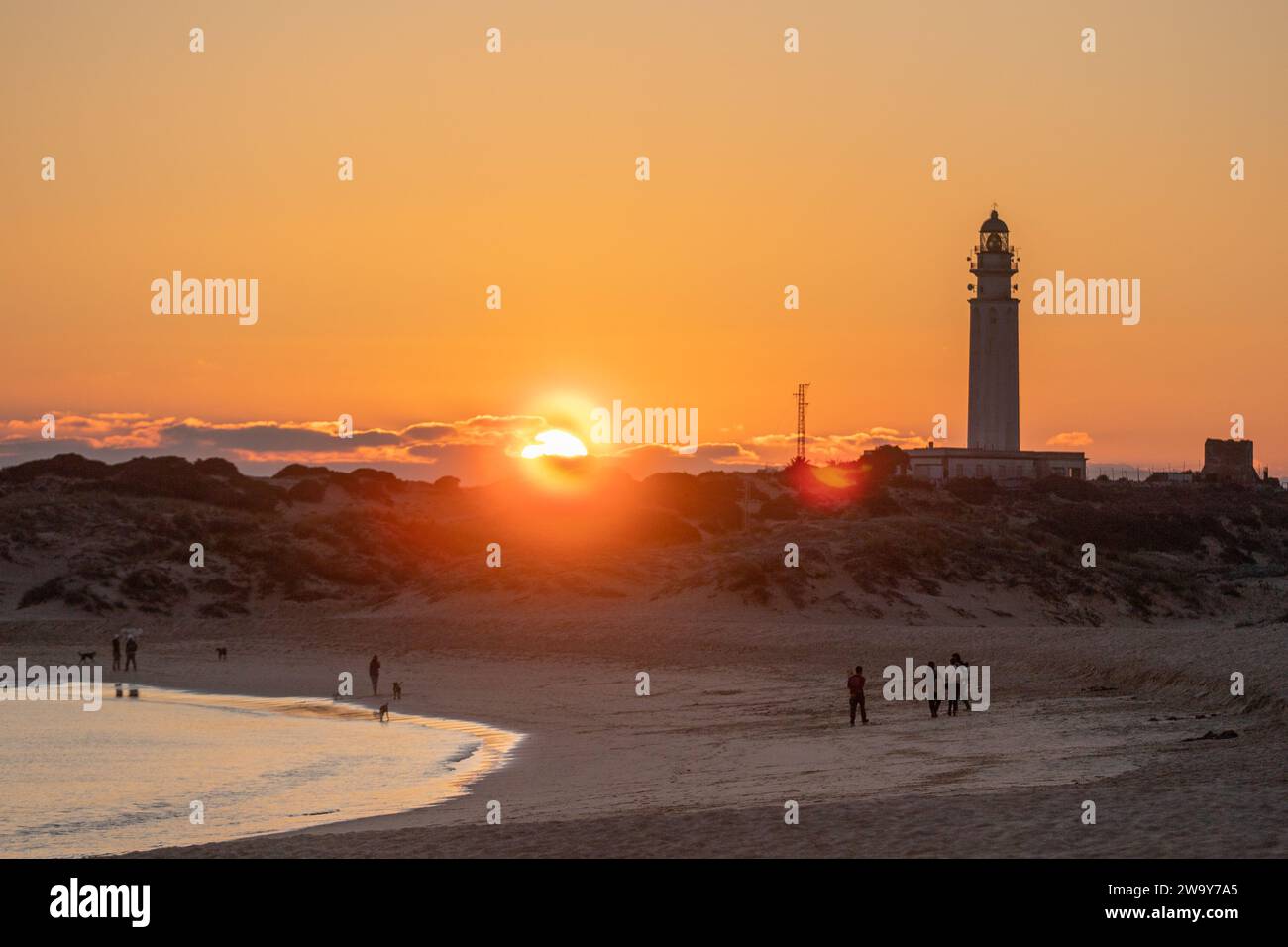 Der Leuchtturm am Strand mit einem klaren Sonnenuntergang. Der Leuchtturm befindet sich in der Küstenstadt Caños de Meca in Südspanien Stockfoto