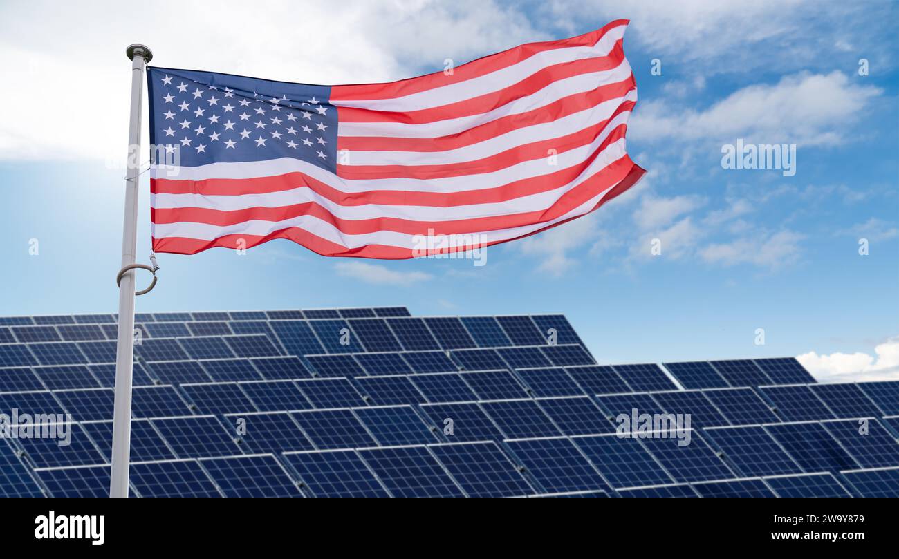 Die amerikanische Flagge flattert auf dem Hintergrund von Solarpaneelen. Symbol für nachhaltige Entwicklung Vereinigte Staaten von Amerika. Stockfoto