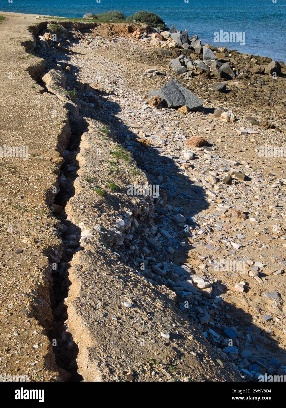 Erosion in der Küstenzone. Der Boden bricht und rutscht ins Meer. Stockfoto