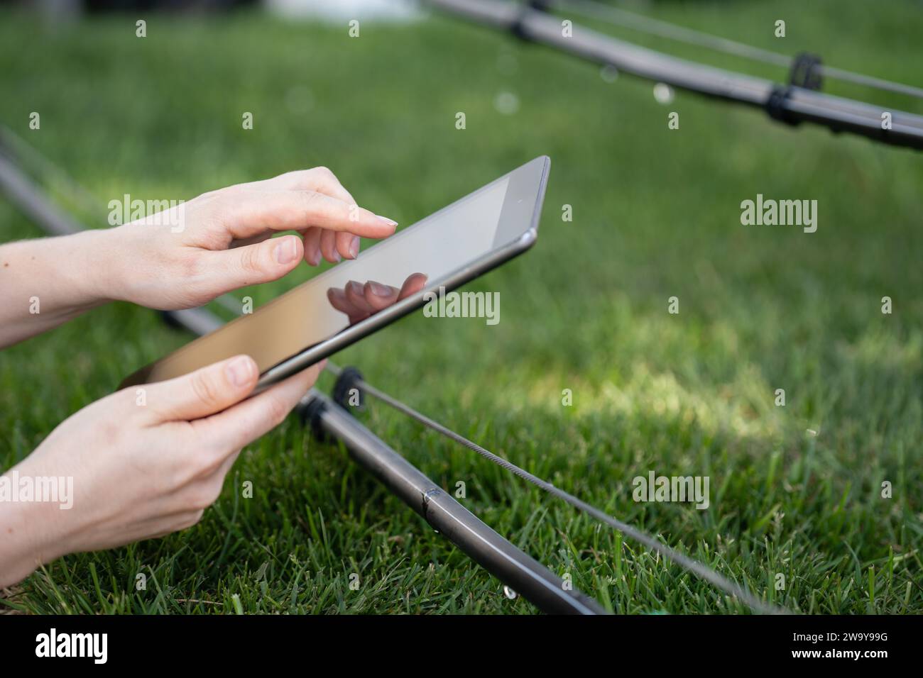 Der Landwirt steuert das Tropfbewässerungssystem mit einem digitalen Tablet. Stockfoto