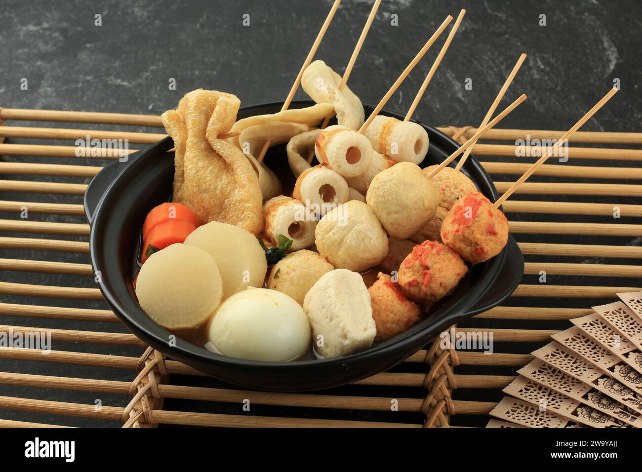 Japanische hausgemachte Oden Fish Ball Fstive Suppe mit Dashi Stock, serviert auf Black Nabe Stockfoto