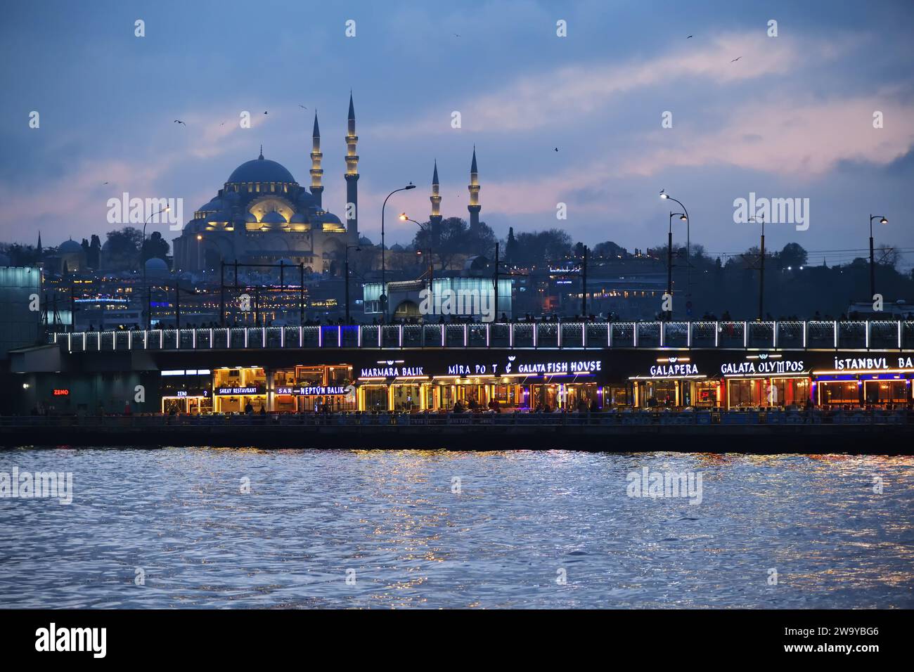 Istanbul, Türkei - 11. Dezember 2023: Blick vom Bosporus auf die Galata-Brücke und die Suleiman- oder Suleymaniye-Moschee am Winterabend Stockfoto